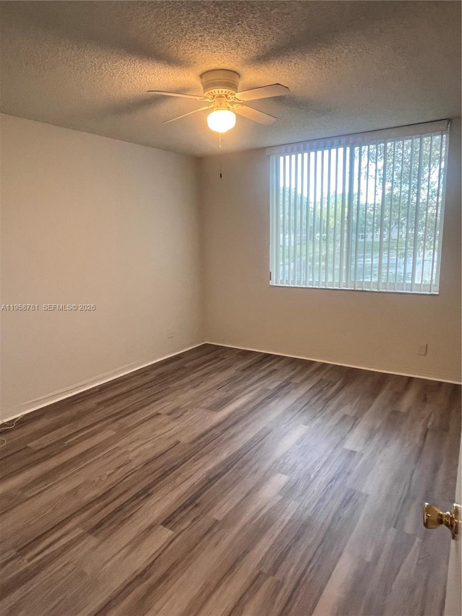 4055 West McNab Road, Unit H211 Pompano Beach, FL 33069 - Photo 9 of 22 wooden floor in an empty room with a window