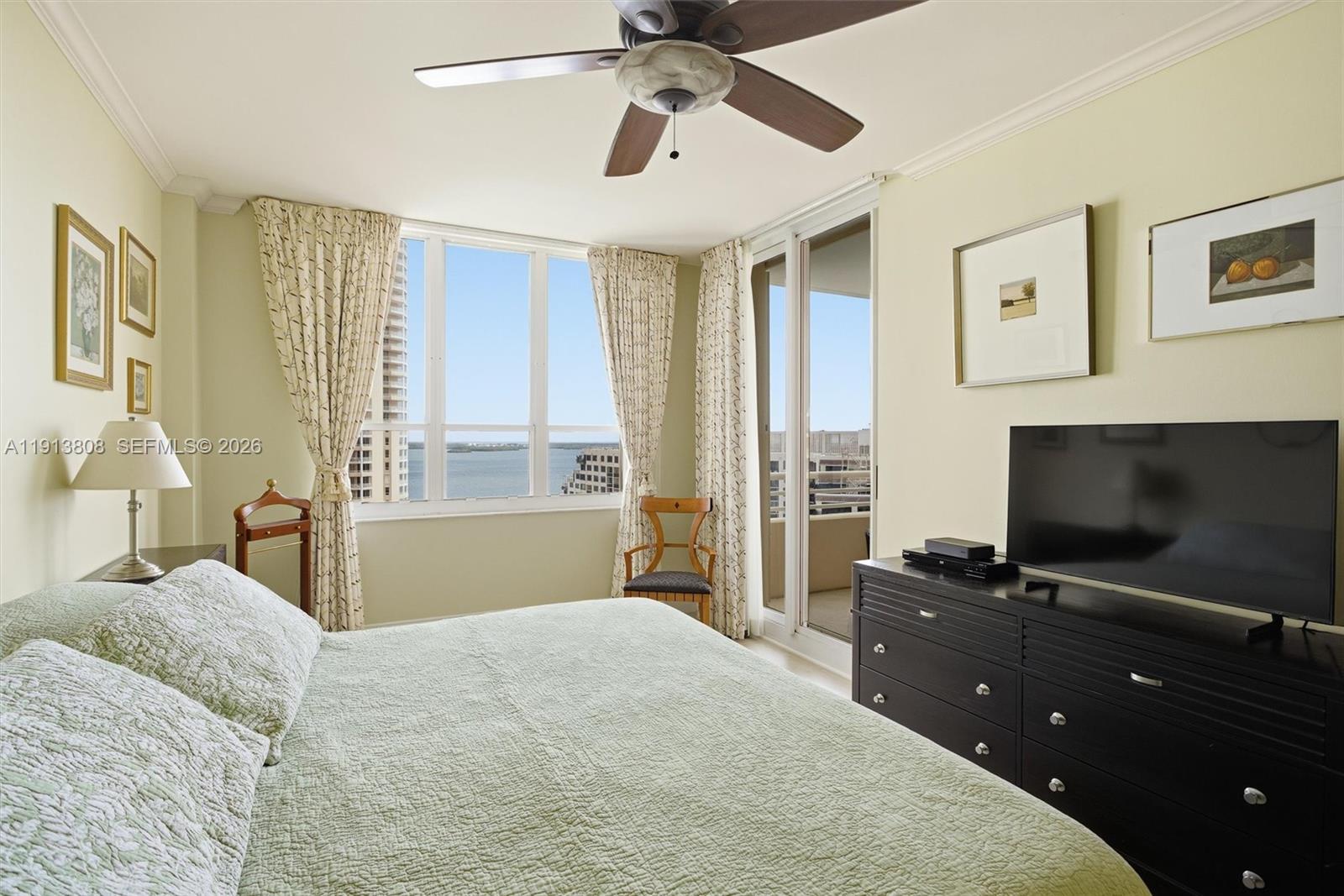 888 Brickell Key Drive, Unit 1903 Miami, FL 33131 - Photo 17 of 38 a bedroom with a bed and a flat screen tv