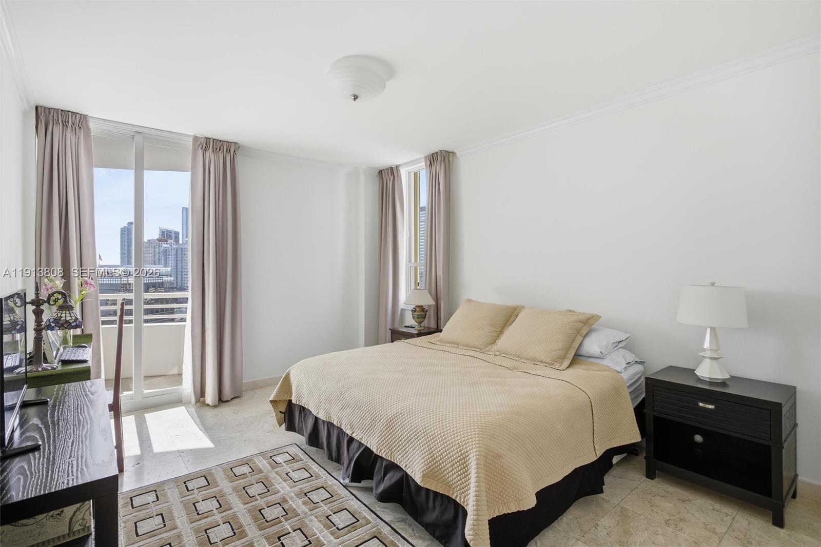 888 Brickell Key Drive, Unit 1903 Miami, FL 33131 - Photo 20 of 38 a bedroom with a bed and a night stand