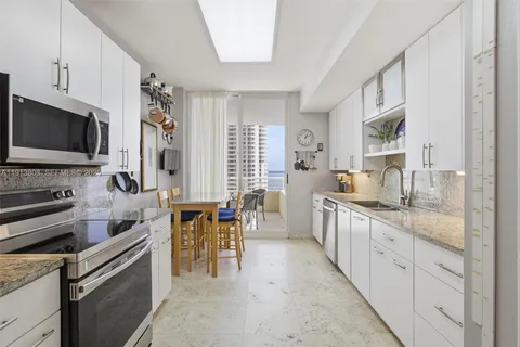 a large white kitchen with cabinets