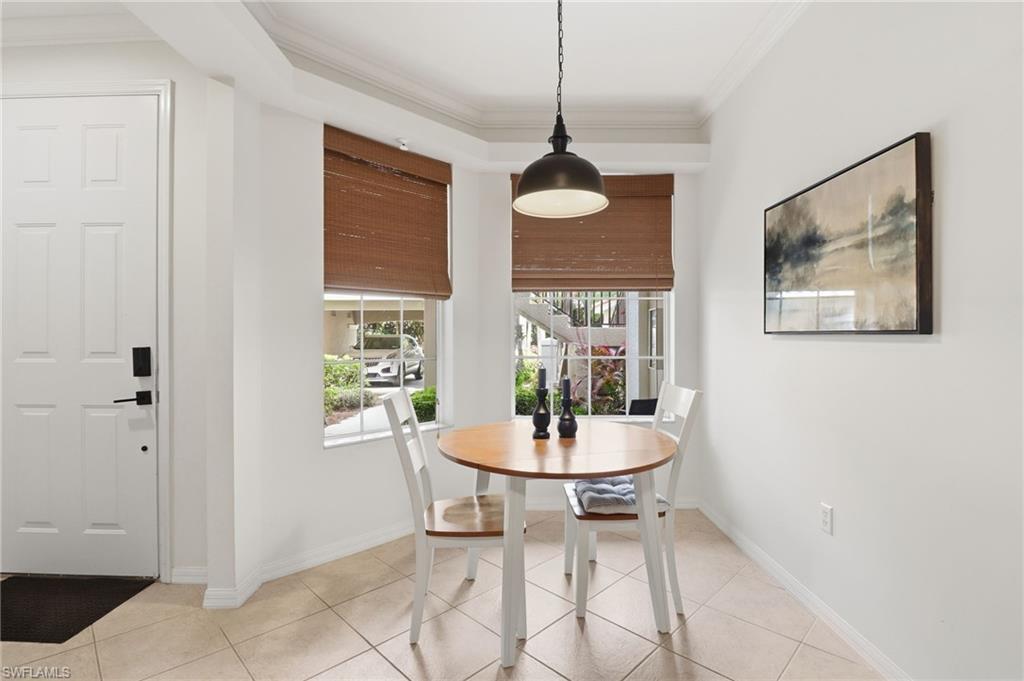 12040 Matera Lane, Unit 104 Bonita Springs, FL 34135 - Photo 13 of 36 a dining room with furniture a window and chandelier