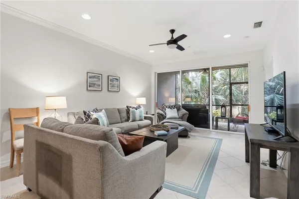 a living room with furniture kitchen view and a flat screen tv