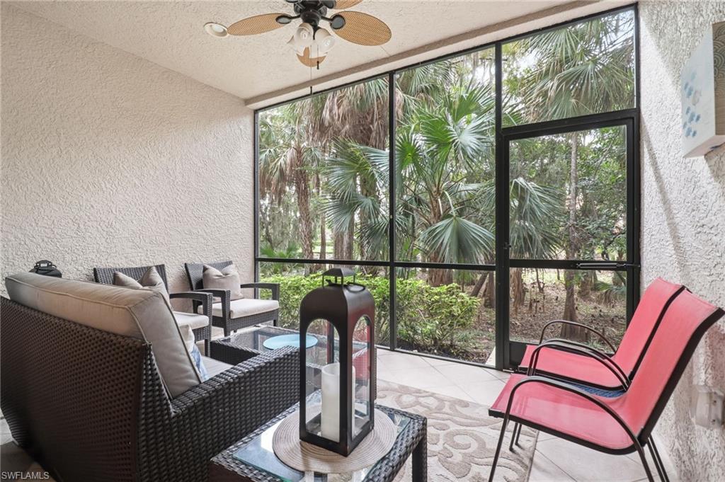 12040 Matera Lane, Unit 104 Bonita Springs, FL 34135 - Photo 26 of 36 a living room with furniture and a floor to ceiling window