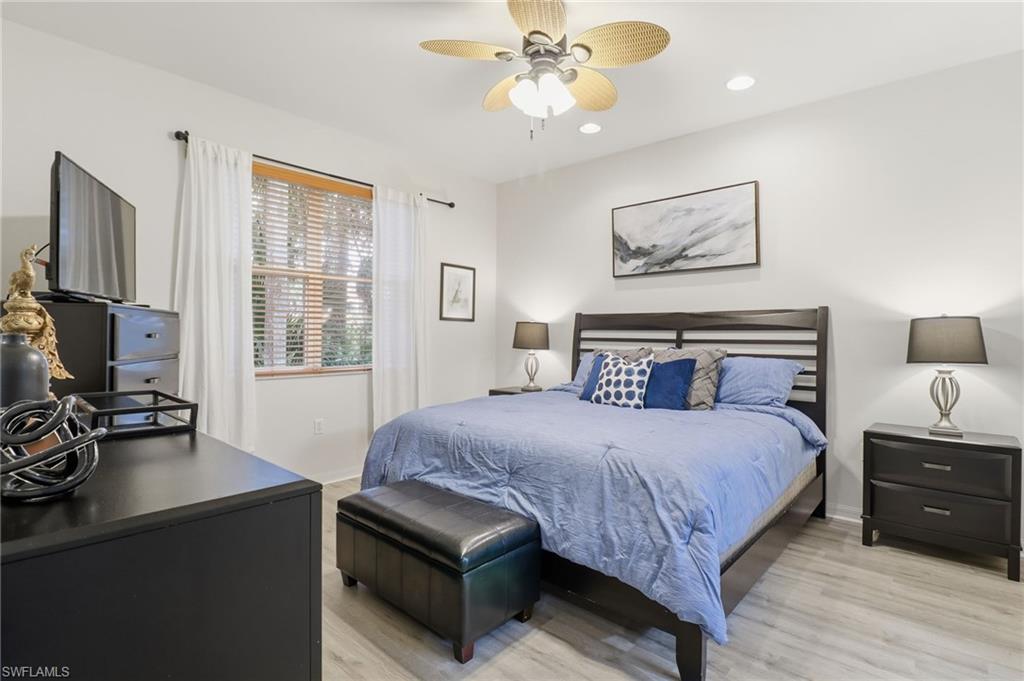 12040 Matera Lane, Unit 104 Bonita Springs, FL 34135 - Photo 28 of 36 a bedroom with a bed and a flat screen tv