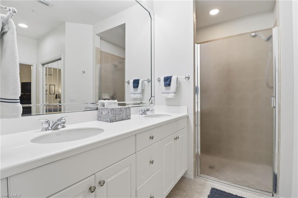 12040 Matera Lane, Unit 104 Bonita Springs, FL 34135 - Photo 29 of 36 a bathroom with a double vanity sink mirror and shower