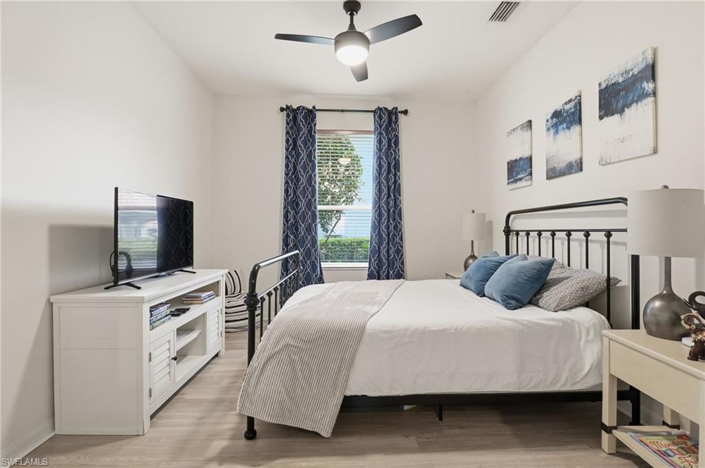 12040 Matera Lane, Unit 104 Bonita Springs, FL 34135 - Photo 30 of 36 a bedroom with a bed and flat screen tv