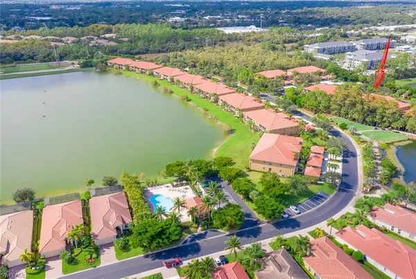 an aerial view of lake and residential houses with outdoor space
