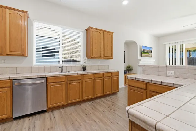a kitchen with stainless steel appliances granite countertop a sink stove and wooden cabinets