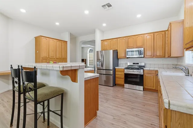 a kitchen with stainless steel appliances wooden floors and wooden cabinets