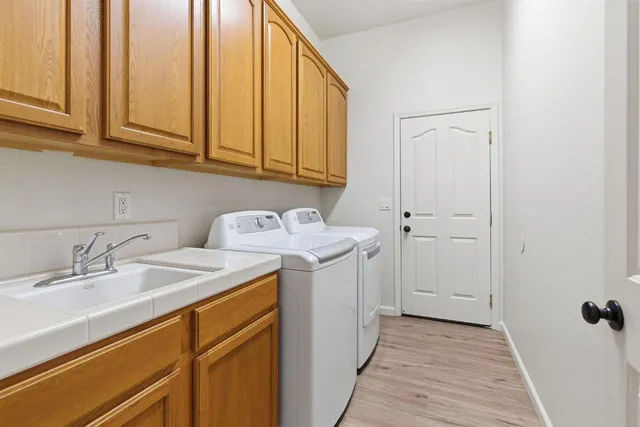 a utility room with sink dryer and washer