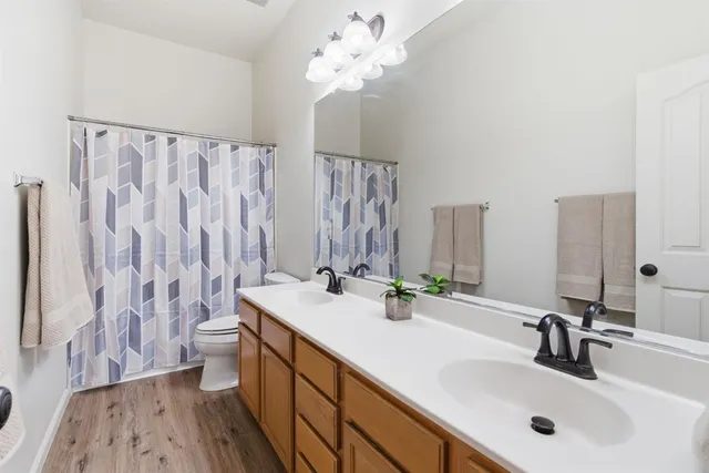 a bathroom with a double vanity sink mirror and shower