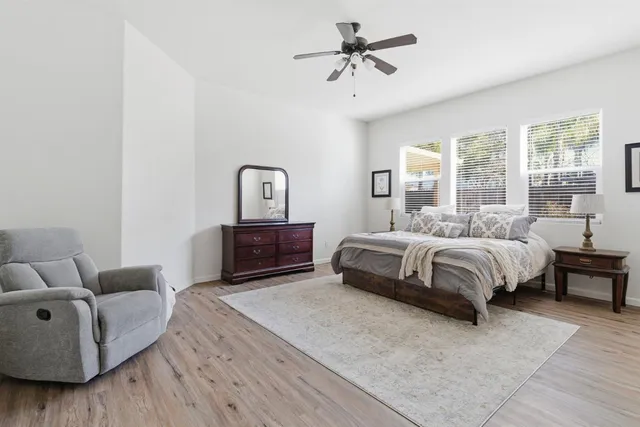 a spacious bedroom with a bed a couch and a window