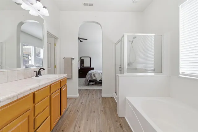a spacious bathroom with a tub sink and mirror