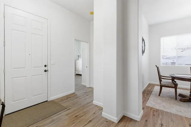 a view of a hallway with wooden floor and furniture