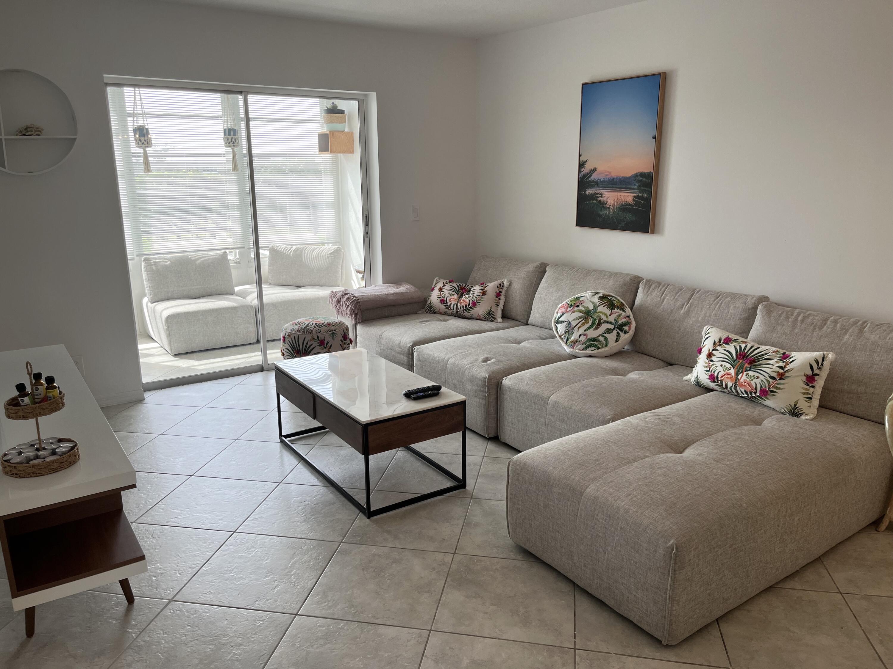 2515 Northeast 1st Court, Unit 411 Boynton Beach, FL 33435 - Photo 4 of 22 a living room with furniture and a floor to ceiling window