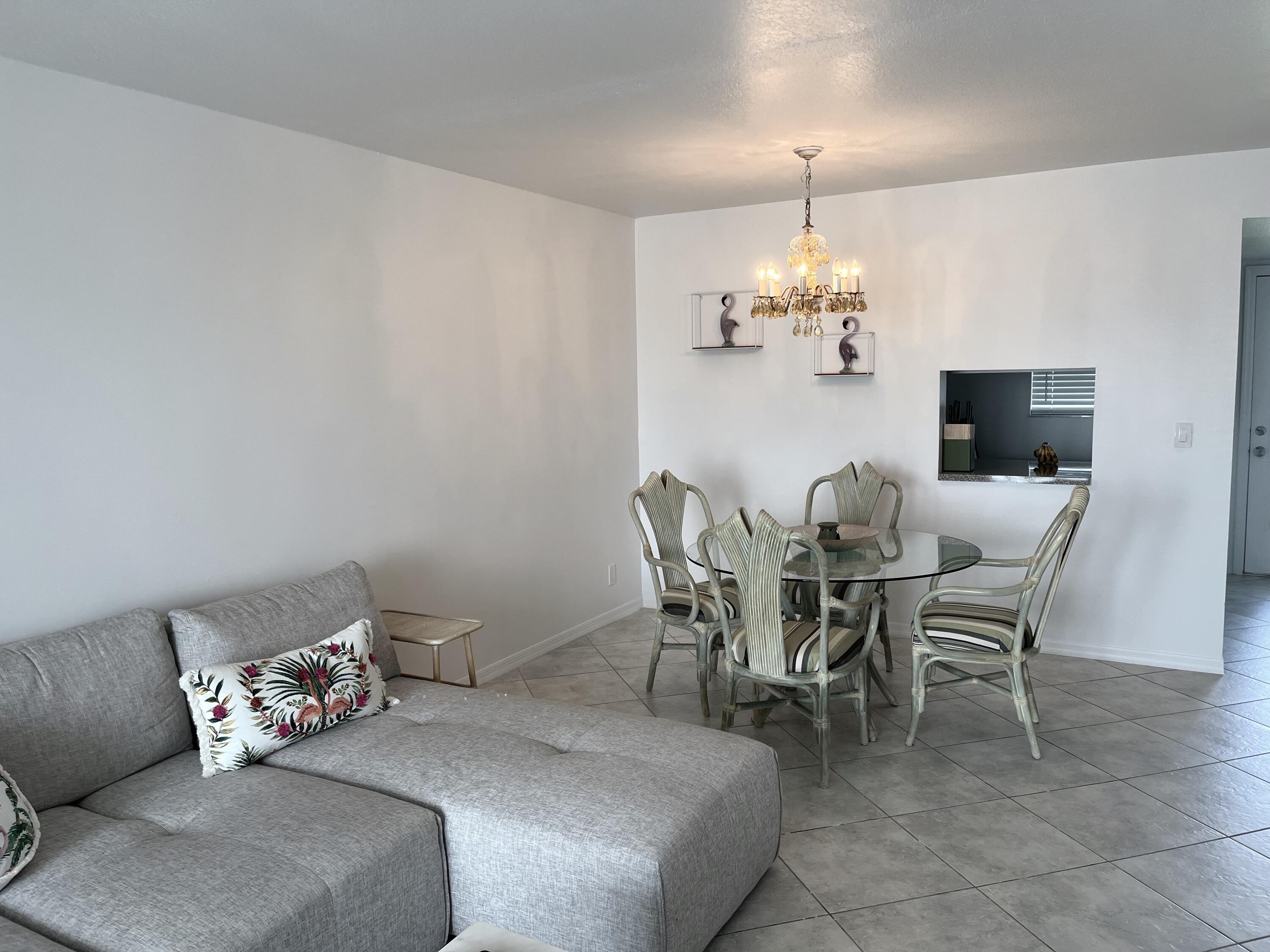 2515 Northeast 1st Court, Unit 411 Boynton Beach, FL 33435 - Photo 5 of 22 a dining room with furniture and chandelier