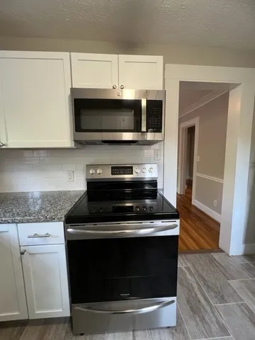 a stove top oven sitting inside of a kitchen