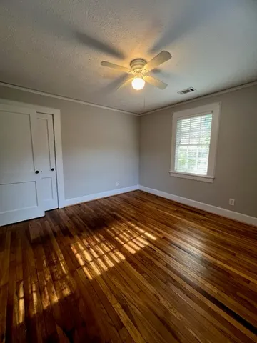 a view of a room with wooden floor and window