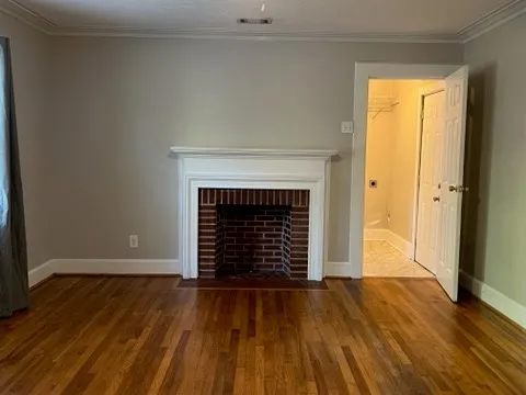 an empty room with wooden floor and fireplace