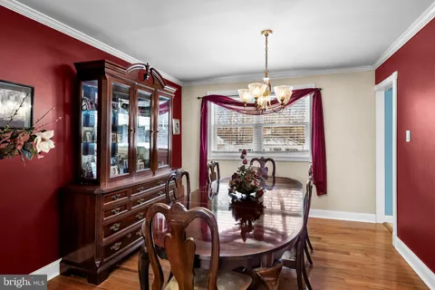a dining room with furniture a chandelier and wooden floor
