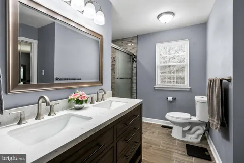 a bathroom with a sink double vanity and a toilet