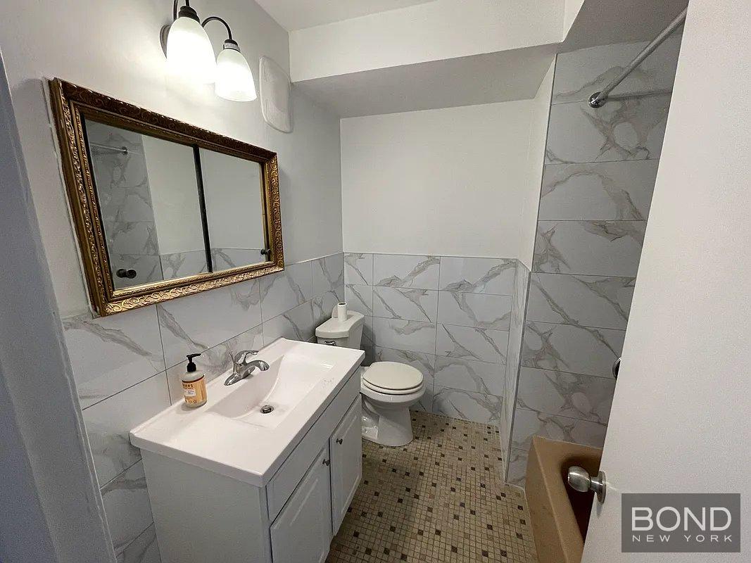 45 Monitor Street, Unit 1 Brooklyn, NY 11222 - Photo 3 of 12 a bathroom with a sink a toilet and mirror
