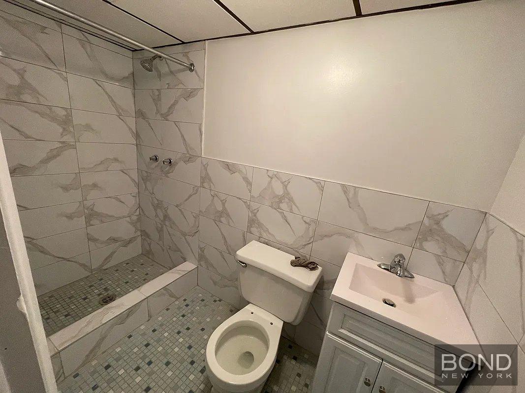 45 Monitor Street, Unit 1 Brooklyn, NY 11222 - Photo 6 of 12 a white toilet sitting next to a shower