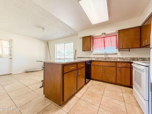 a kitchen with stainless steel appliances granite countertop a stove a sink and a microwave