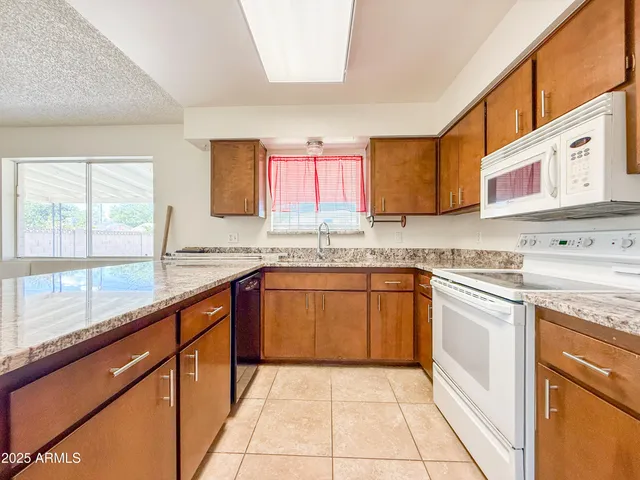 a kitchen with stainless steel appliances granite countertop a stove a sink and a microwave