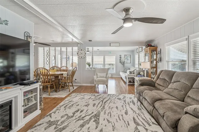 a living room with furniture a flat screen tv and a dining table