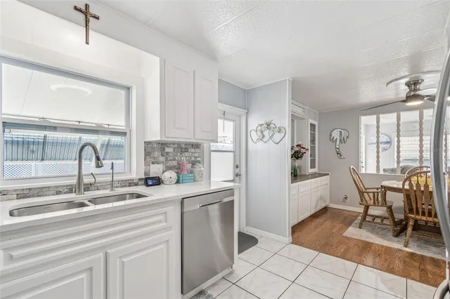 a kitchen with white cabinets and dining table