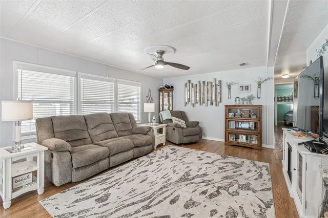 a living room with furniture a flat screen tv and a dresser