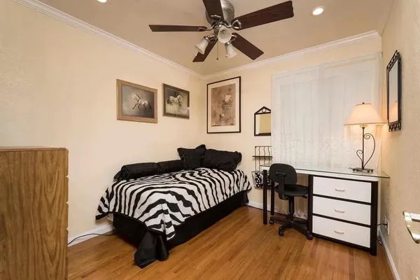 a bedroom with a bed wall painting and a lamp