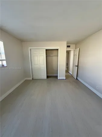an empty room with a window and a ceiling fan