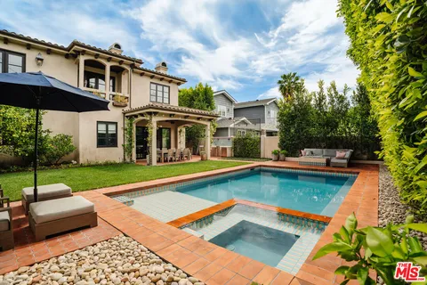 a view of a house with swimming pool and a yard