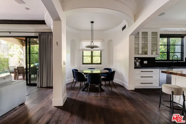 a dining room with furniture a chandelier and wooden floor