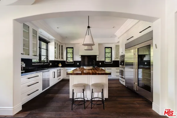 a kitchen with a dining table chairs cabinets and stainless steel appliances