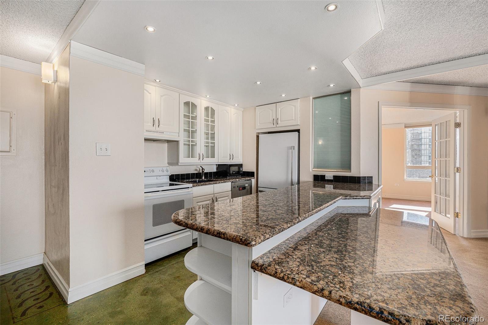 a kitchen with stainless steel appliances granite countertop a sink and a refrigerator