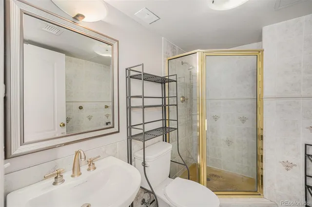 a bathroom with a shower a sink and toilet