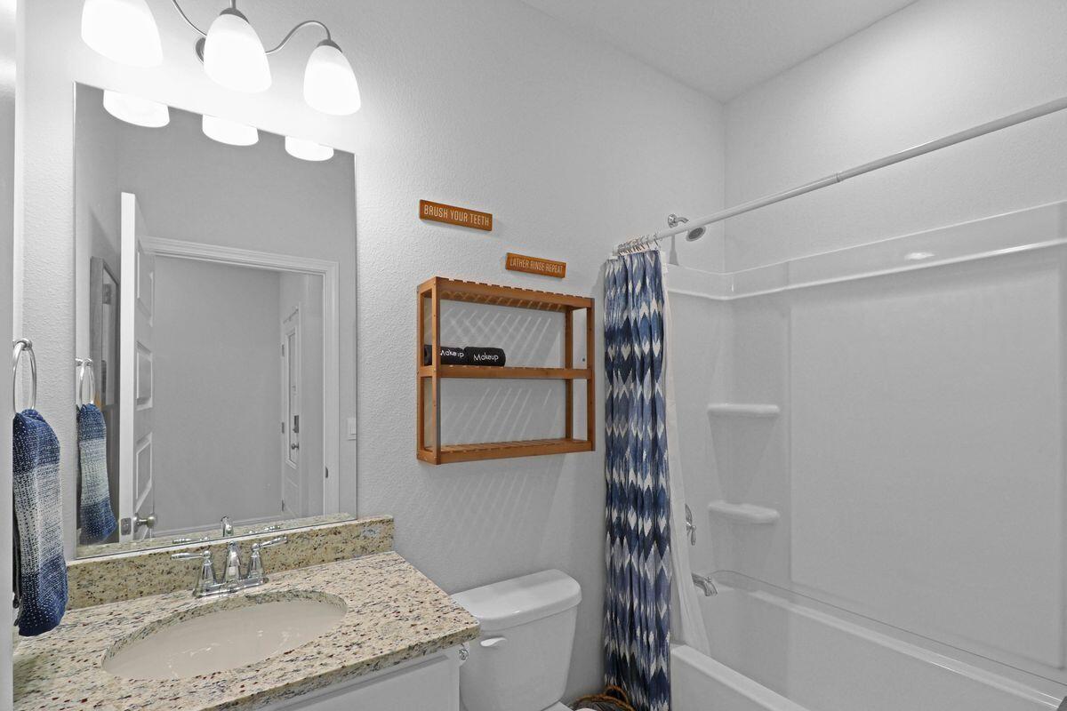 769 Backwater Road Port St. Joe, FL 32456 - Photo 17 of 45 a bathroom with a granite countertop sink a toilet and shower