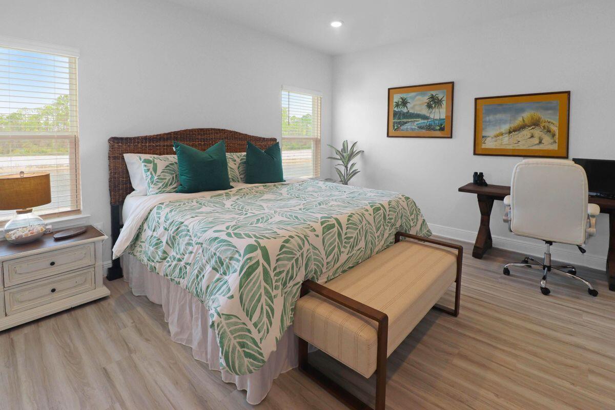 769 Backwater Road Port St. Joe, FL 32456 - Photo 20 of 45 a bedroom with a bed lamp and paintings on the wall