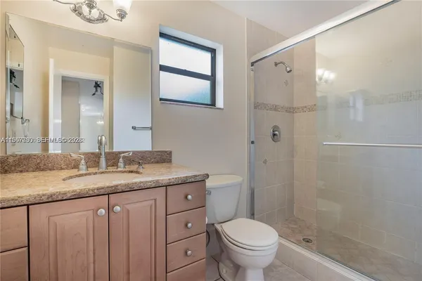 a bathroom with a granite countertop sink toilet and shower