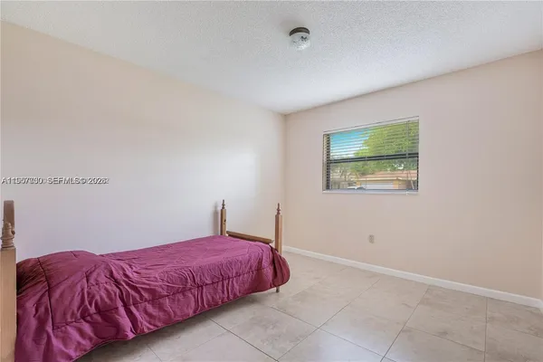 a spacious bedroom with a bed and a painting on the wall