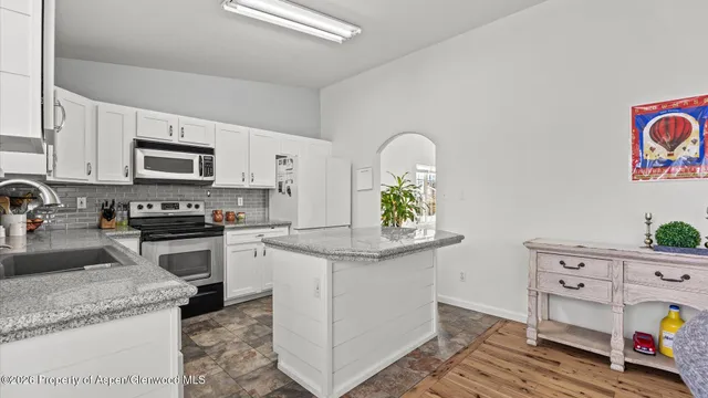 a kitchen with granite countertop a sink stove and cabinets