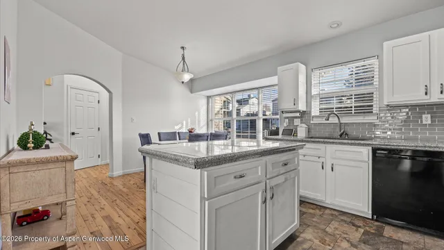 a kitchen with granite countertop a sink stove and cabinets