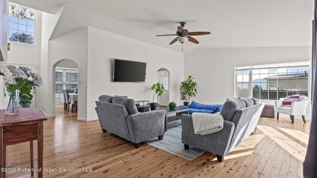 a living room with furniture a flat screen tv and a floor to ceiling window
