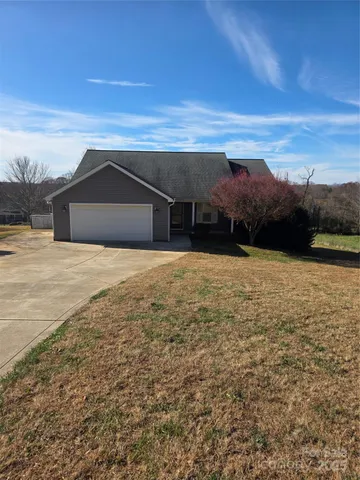 a view of house with yard and mountain in background