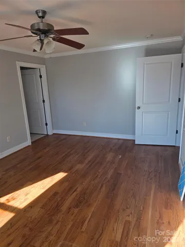a view of an empty room with cabinet and a window