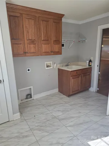 an empty room with wooden floor fireplace and windows