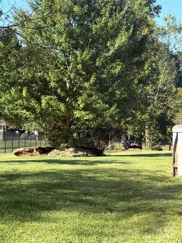 a view of a house with a big yard and island in the background